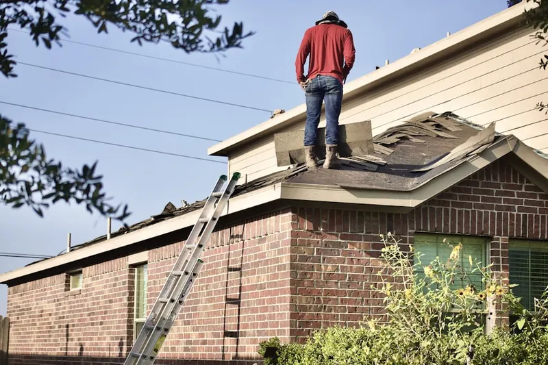 Professional roofer working on a residential roof in Binghampton-Lester